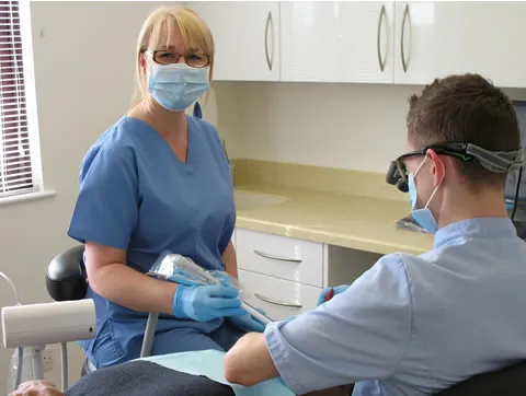 A hygienist treating a patient at the clinic